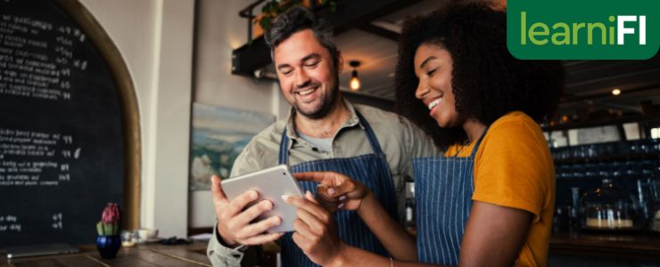 A manager teaching someone how to use the tablet in their tourism and hospitality business