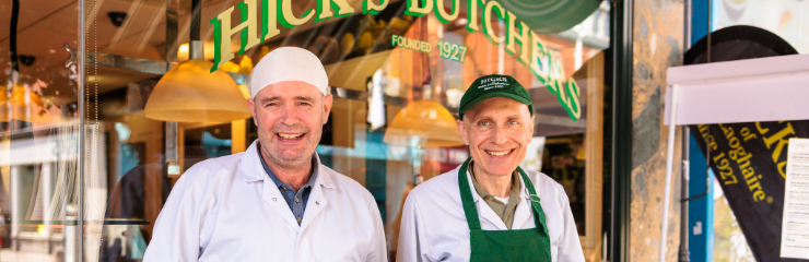 Two butchers in front of their shop
