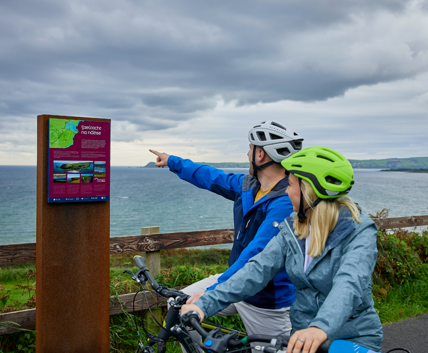 Two cyclists pointing towards a map