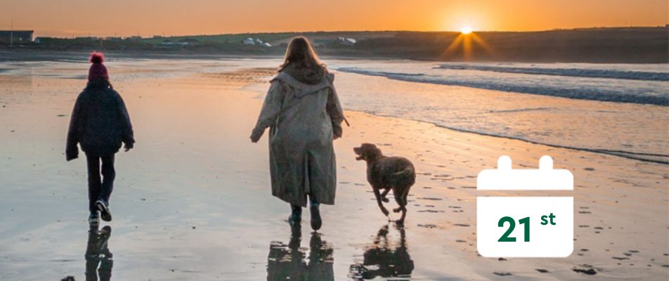 A lady walking on the beach and a calendar that says 21st