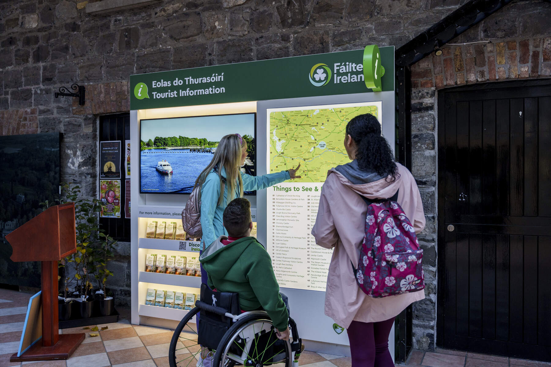Three people looking at a map on a stand
