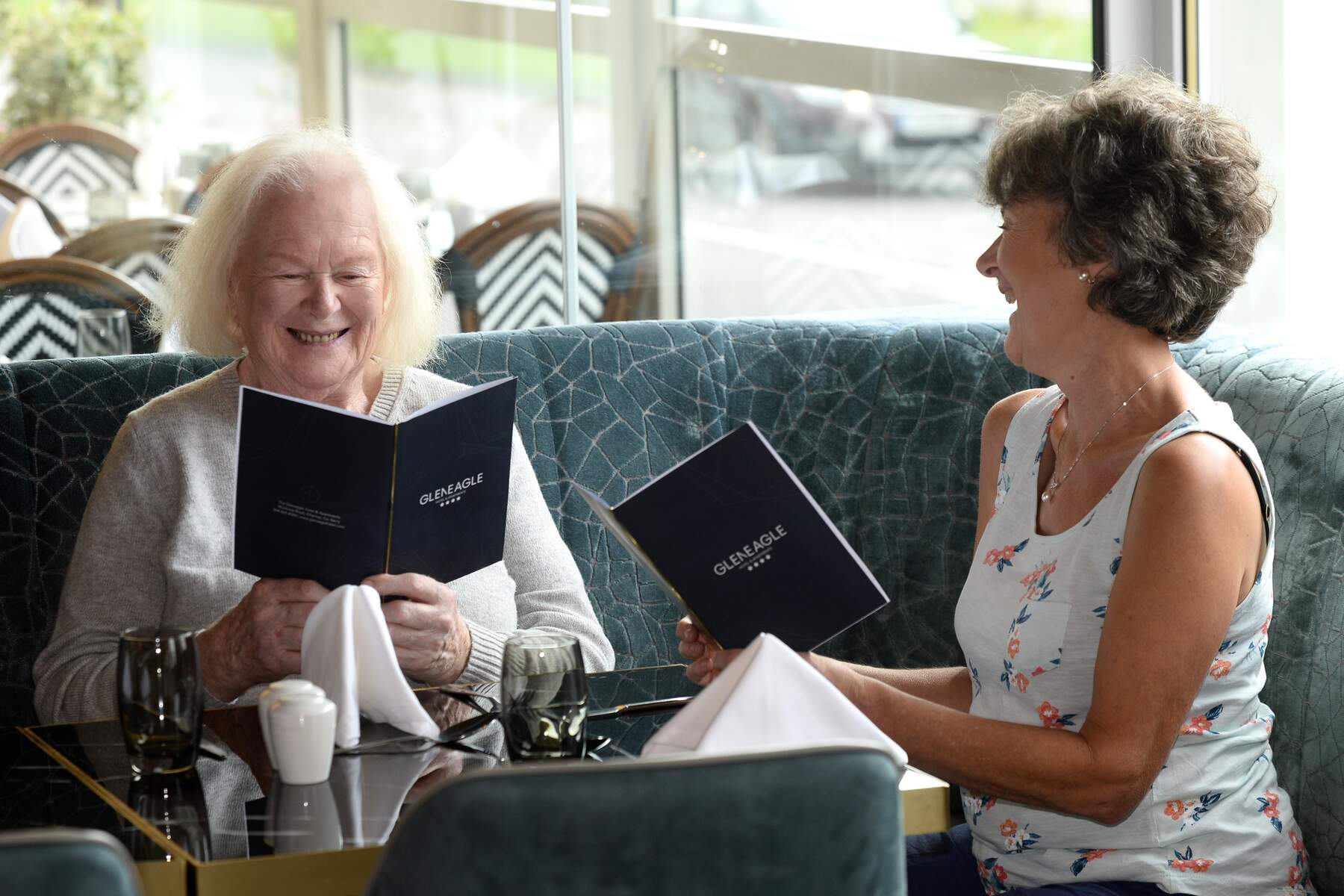 Two women reading a menu at a dinner table
