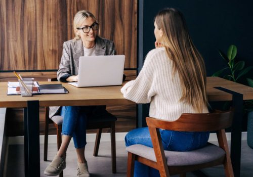 Two women speaking at a table