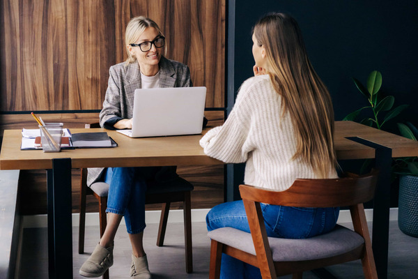 Two women speaking at a table