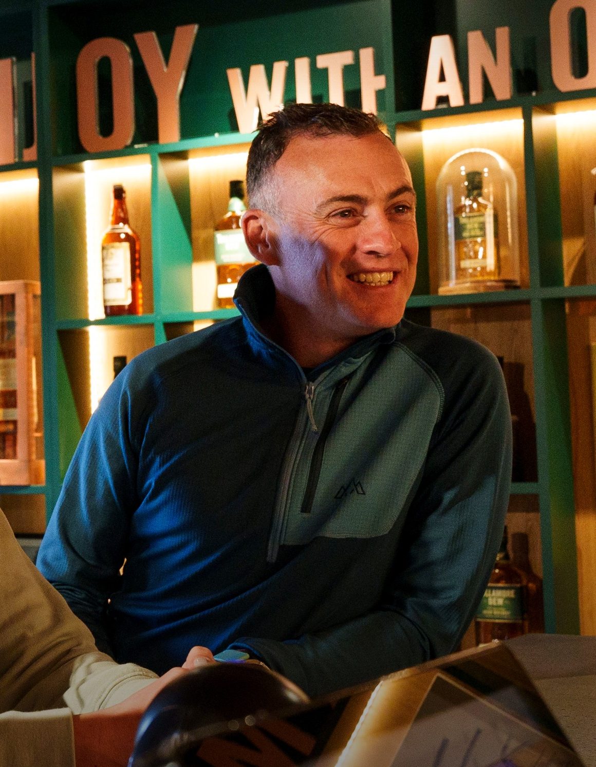 Two people waiting and smiling at a till.